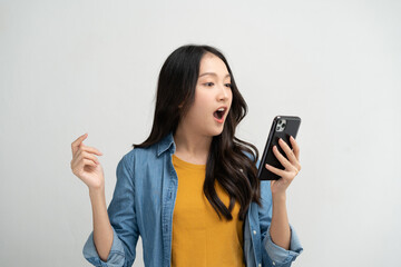 Happy Asian woman holding a smartphone and winning the prize.