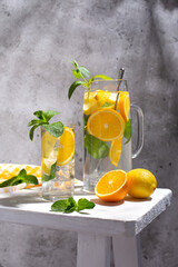 Summer refreshing lemonade drink or alcoholic cocktail with ice, mint, lemon and orange slices.  Fresh healthy cold lemonade