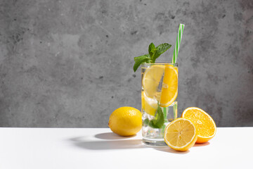 Summer refreshing lemonade drink or alcoholic cocktail with ice, mint, lemon and orange slices.  Fresh healthy cold lemonade