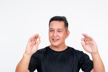A middle aged Asian man choosing between two different vitamin supplements, isolated on a white...