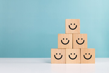 Service rating,winner,satisfaction and positive feedback concept. Smiling face emoticon on wooden...