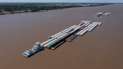 A towboat, known as a pusher, pushes barges full of cargo up the Mississippi River near downtown...