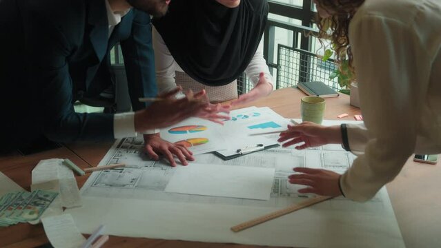 Architecture designers architects contractors diverse businessman businesswomen talk discuss blueprints paper drafting design project Arabian man women muslim hijab discussion business teamwork office