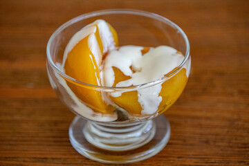 Traditional dessert of peaches in syrup with cream
