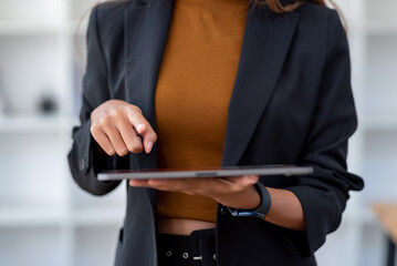 Businesswoman professional using a tablet in an office setting, highlighting modern technology and business processes.