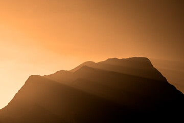 sunset with sun rays over the mountains