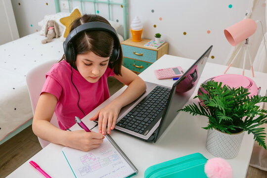 Young girl studying in her colorful bedroom