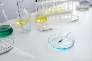 Close-up a laboratory Petri dish with test litmus paper for testing an alkaline acid solution.