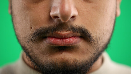 Obraz premium Man's mouth, close-up, on a green background