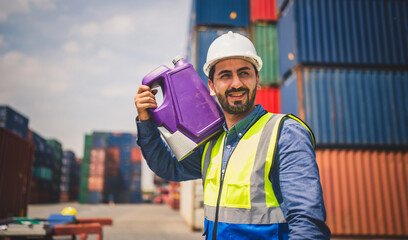 Portrait of Engineer or foreman wears PPE checking container storage with cargo container...