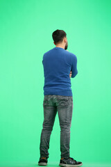 A man, full-length, on a green background, thinks