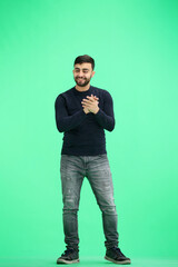 A man, full-length, on a green background, claps