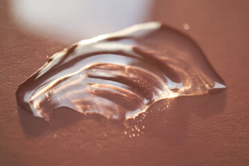 Beautiful volumetric drop of cosmetic product on a pink background.