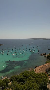Playa illetas with clear turquoise waters and sunbathers on the beach, mallorca, spain, aerial view