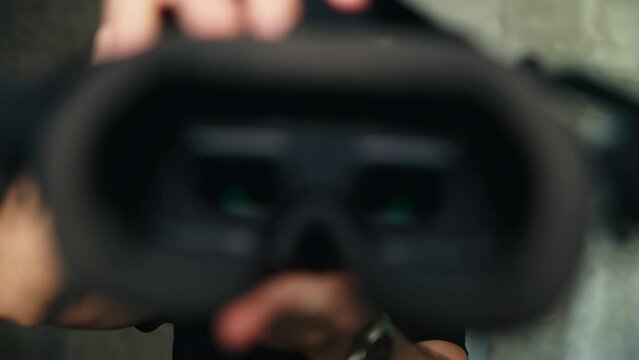 Man takes off modern FPV drone goggles or a VR headset off YOU