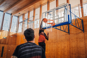 Portrait of an african basketball player dunking the ball into hoop