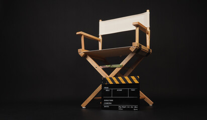 Director chair and yellow clapper board on black background