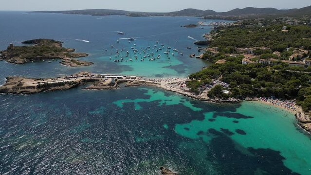Playa illetas with clear turquoise waters and sunbathers on the beach, mallorca, spain, aerial view