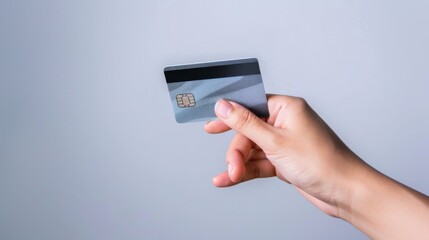 Fototapeta premium hand hold a credit card with neutral background, only hand and credit card