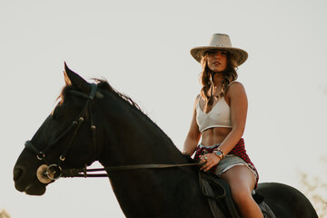Portrait of western styled rider horseback riding at homestead.