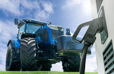 Electric vehicles charging station on a background of agricultural tractor. Concept