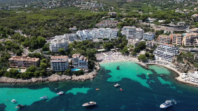 Playa illetas with clear turquoise waters and sunbathers on the beach, mallorca, spain, aerial view