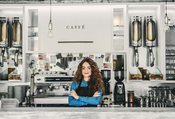 Beautiful female barista working in coffee shop. University student working part-time in cafe.