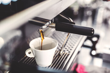 Espresso machine pouring fresh black coffee, close up.