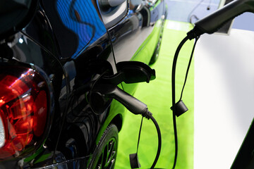 Close up of electric car inlet with a connected charging cable.