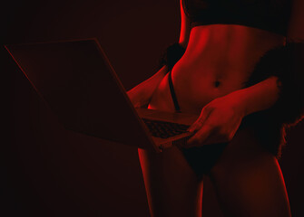 A young webcam model girl  in front of a laptop. She communicates on a white bed in the bedroom.