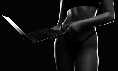 A young webcam model girl  in front of a laptop. She communicates on a white bed in the bedroom.