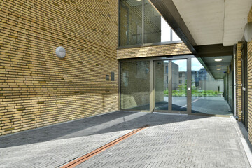 Modern building entrance with glass doors and brick walls