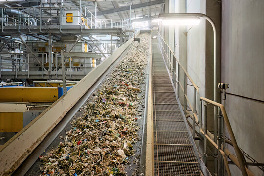 Conveyor belt transporting refuse-derived fuel (RDF) with motion blur effect in an industrial recycling facility, highlighting the dynamic waste sorting and processing system for renewable energy.