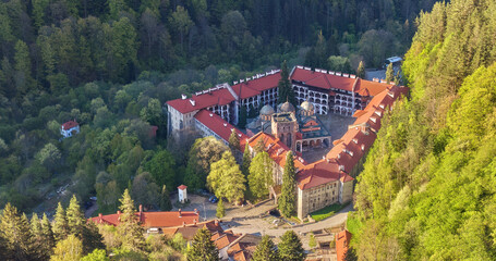 Aerial view of the iconic Rila Monastery, showcasing its red-tiled roofs, intricate architecture,...