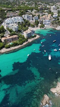 Playa illetas with clear turquoise waters and sunbathers on the beach, mallorca, spain, aerial view