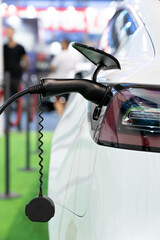 Close up of electric car inlet with a connected charging cable.