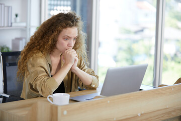 young woman working on laptop computer and feeling tired and worry from hard work in the office