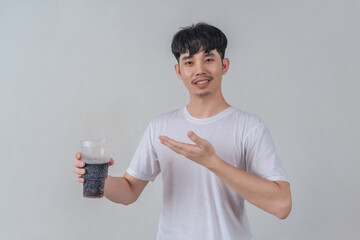 Handsome young man drinks soda and holding plastic cup and soda bottle.