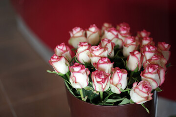 A large bouquet of pink and white roses in a vase.
