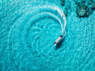 Aerial view of the speed boat in clear azure water on summer sunny day. Top drone view of fast...