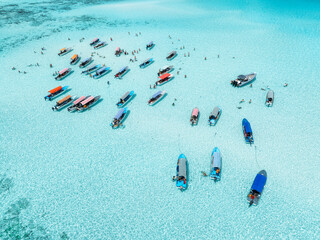 Aerial view of colorful boats, sea bay with azure water in summer. Mnemba island, Zanzibar. Top...