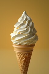 Vanilla soft serve ice cream cone on a warm yellow background with swirled creamy texture