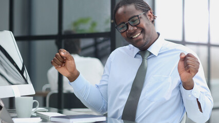 happy man working in the office. raised his hands joyfully