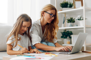 Mother and daughter collaborating on a laptop together against a minimalistic white background