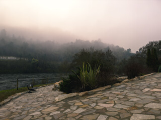 Misty Pathway by the River with Foggy Hills