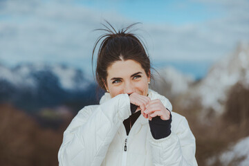 Smiling young woman covering mouth with hand and looking away