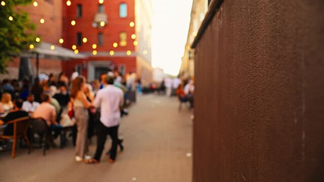 Night street scene with outdoor dining and festive lights, creating a vibrant urban atmosphere