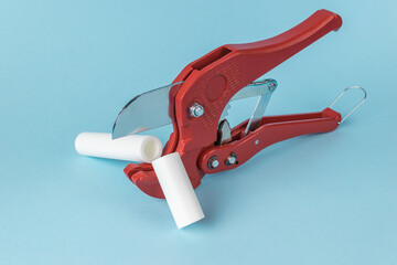 Red PVC Pipe Cutter on Light Blue Background - Plumbing Tool for Cutting Plastic Pipes