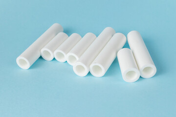 White Cylindrical Plastic Pipes on Light Blue Background
