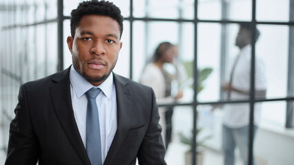 Portrait of a serious businessman in a black suit in the office